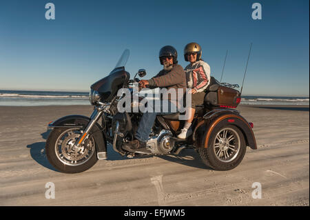 Un giovane godendo di una corsa sulla Daytona Beach litorale con le loro Harley Davidson Trike motociclo Foto Stock