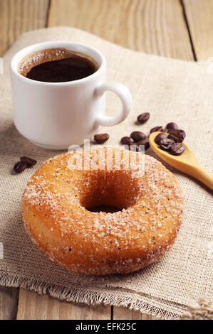 La prima colazione con dolci ciambella e caffè sul tavolo in legno Foto Stock