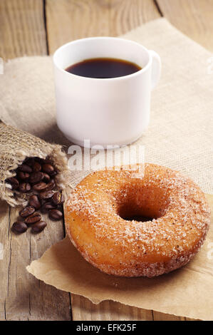 La prima colazione con dolci ciambella e caffè sul tavolo in legno Foto Stock