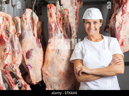 Fiducioso del macellaio in piedi in macelleria Foto Stock