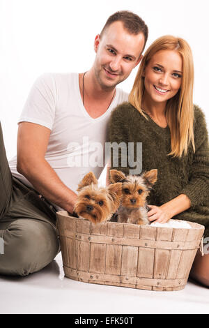 Amore giovane con due Yorkshire terrier in basket - moda autunno Foto Stock