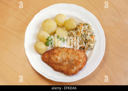 Cotoletta di maiale con pomodori bolliti e insalata di verdure Foto Stock