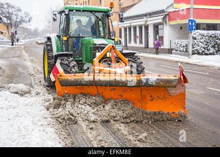 Trattore spazzaneve rimozione neve da city road Foto Stock