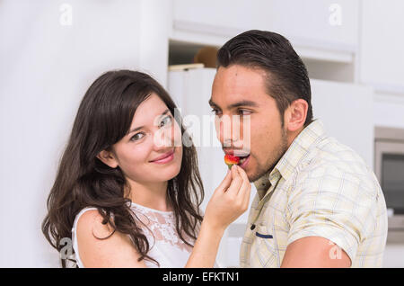 Carino coppia felice di alimentare ciascun altro una fragola Foto Stock