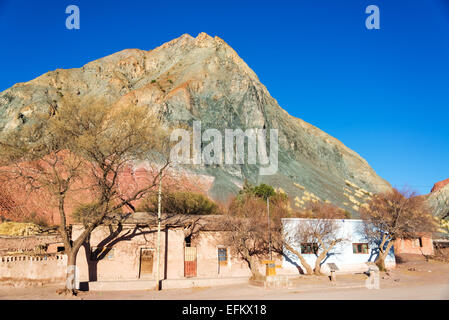 Verde, arancione e rosso collina che sovrasta la piazza del Monte, una piccola cittadina in stile rustico vicino a Tupiza, Bolivia Foto Stock