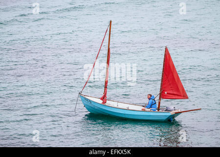 Uomo in barca a vela off sant Agnese, isole Scilly, Regno Unito Foto Stock