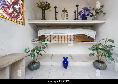 Bara di legno coperto in una copertura di colore bianco con fiori in un ben conservato mausoleo o santuario nel famoso Cimitero di Recoleta, Buenos Aires, Argentina Foto Stock