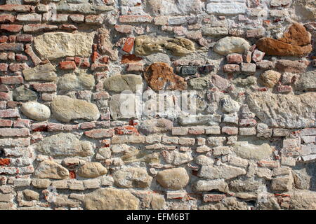 Antico casolare in pietra e mattoni rossi parete sulla fortezza medievale Foto Stock