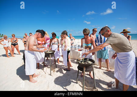 Repubblica Dominicana. I turisti in competizione in una paella cook-off sulla spiaggia di Punta Cana. 2015. Foto Stock