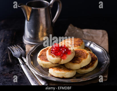 Cottage cheese pancake con confettura di ribes su vintage piastra di metallo messa a fuoco selettiva Foto Stock