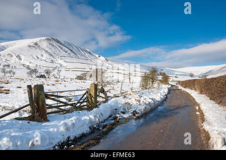 Un vicolo del paese in un snowy vale di Edale, Peak District, Derbyshire. Porta di campo accanto alla strada stretta. Foto Stock