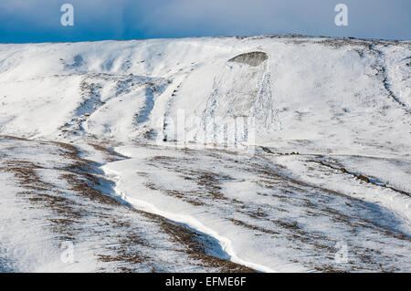 Sole sui pendii innevati di colline a Edale valley, Derbyshire. Una valanga di piccole dimensioni sul lato della collina. Foto Stock