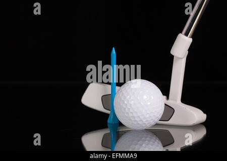 Golf putter e diverse attrezzature da golf sul vetro nero scrivania Foto Stock