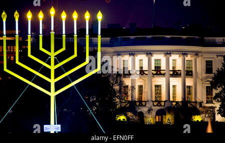 Celebrazione nazionale della Menorah Hanukkah Washington D.C. | WASHINGTON D.C., Stati Uniti — La Menorah nazionale è illuminata sull'Ellipse vicino alla Casa Bianca, segnando Hanukkah con i suoi nove rami illuminati davanti alla residenza presidenziale addobbata per il Natale. Accesa per la prima volta nel 1979, l'imponente menorah viene riaccesa ogni notte durante la festa e ha attirato la partecipazione presidenziale negli anni passati. Foto Stock