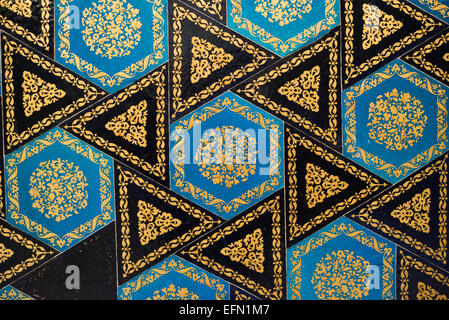 Mattonelle di mosaico ottomano del XVI secolo chiosco piastrellato Istanbul Turchia | ISTANBUL, Turchia - piastrelle triangolari blu esagonali e nere brillano con motivi floreali dorati in questo pannello a mosaico ottomano del XVI secolo dal chiosco piastrellato (Cinili Köşk). Le ceramiche originariamente decoravano una fontana aggiunta nel 1590 sotto il sultano Murad III, all'interno di un padiglione del sultano Mehmed II costruito nel 1472 in stile architettonico timuride e persiano. Foto Stock