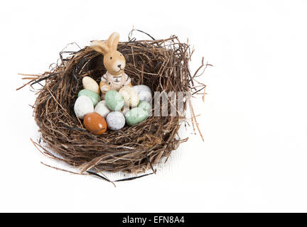 Nido di Pasqua decorate con le uova e il coniglio di fronte a uno sfondo bianco Foto Stock