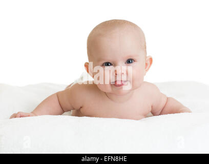 Carino sorridente baby che mostra la linguetta giacente su asciugamano bianco Foto Stock