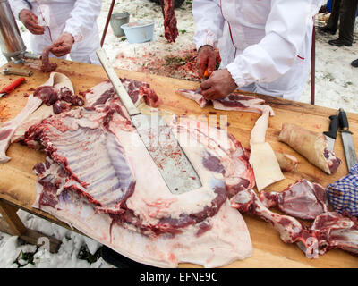 Macellerie lavora con carne di maiale e di preparare le salsicce Foto Stock