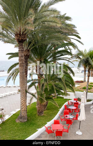 Posti a sedere e ombrelloni istituito al di fuori ristorante cafe vicino a Playa Jardin beach, Puerto de la Cruz, Tenerife, Spagna Foto Stock