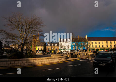 Donegal Town il diamante come la luce del sole si rompe in nuvole temporalesche. Contea di Donegal Irlanda .Street scene della vita quotidiana. Foto Stock