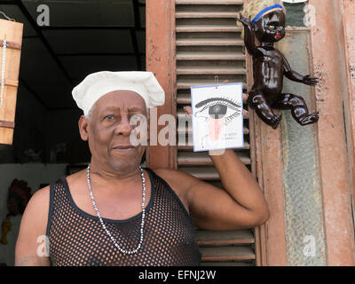 Un modello rilasciato immagine di un uomo Santero tenendo un cartello con una pittura del 'occhio cattivo' nella Habana Vieja, Cuba. Foto Stock
