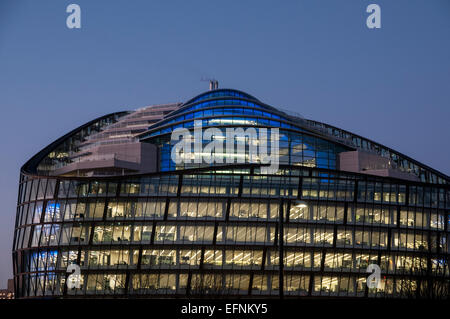 Moderno edificio di office al tramonto con luci colorate in Windows Foto Stock