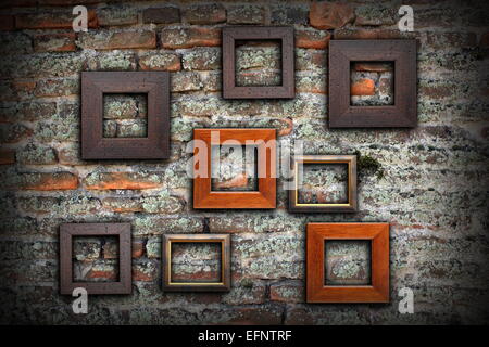 Grungy vecchio muro pieno di cornici di legno per il vostro messaggio o disegno, sfondo artistico Foto Stock