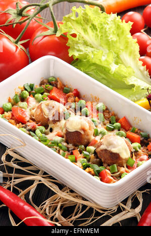 Casseruola di riso con polpette di carne e verdure su sfondo di legno Foto Stock