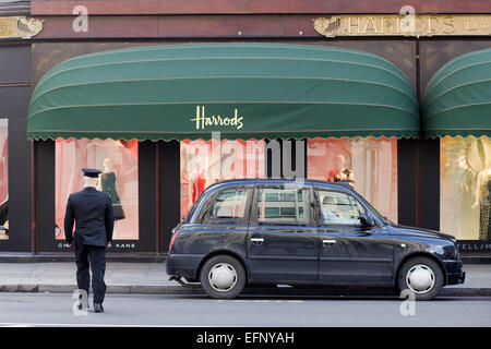 La Harrods facciata di edificio con autista e taxi al di fuori della cabina Foto Stock