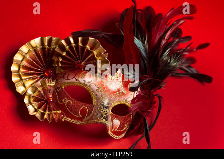 Un rosso e oro veneziano, Mardi Gras maschera su uno sfondo rosso Foto Stock