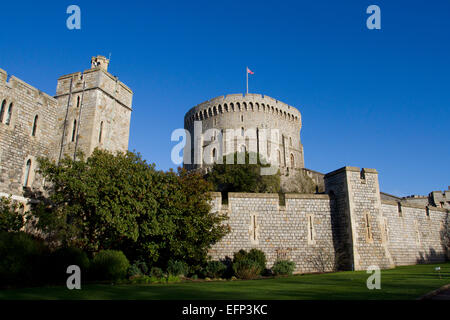 Round Tower (mantieni) e pareti esterne al Castello di Windsor, Berkshire, Inghilterra con Unione Jack battenti in gennaio Foto Stock