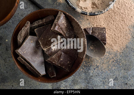 Dark Chocolate chunk nella ciotola di legno, su tavola in legno di quercia Foto Stock