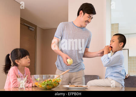 Padre e figli giocare in cucina Foto Stock