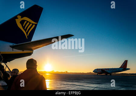 Bristol, Regno Unito. Il 9 febbraio, 2015. 9 febbraio 2015. Regno Unito meteo. L'aeroporto di Bristol, Inghilterra. I passeggeri di salire a bordo di un volo Ryanair a Dublino a sunrise come un aereo Easyjet taxi. Credito: Richard Wayman/Alamy Live News Foto Stock