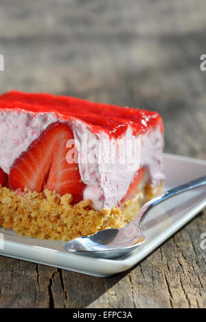 Fetta di Strawberry Cheesecake su un tavolo di legno Foto Stock