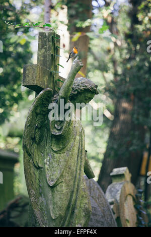 Statua di donna con Red Robin appollaiato su un dito teso, il cimitero di Highgate a Londra, Inghilterra, Regno Unito, Europa Foto Stock