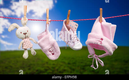 Vestiti del bambino sulla stendibiancheria in esterni Foto Stock