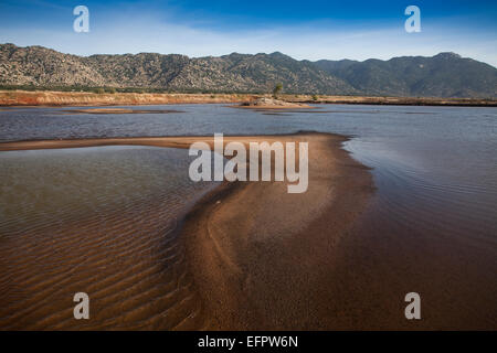 Montagna paesaggio costiero vicino a Ca Na, in primo piano un lago artificiale per la produzione di sale, Ninh Thuan, Vietnam Foto Stock