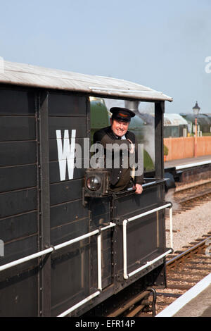 La protezione di un treno di merci sorrisi come egli passa attraverso la stazione di Williton sulla West Somerset Railway nel suo Great Western Railwa Foto Stock