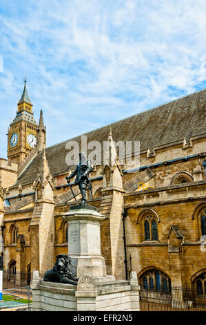 Signore Oliver Cromwell statua al di fuori del Palazzo di Westminster, la Casa del Parlamento, con il Big Ben in background. Londra, Regno Unito Foto Stock
