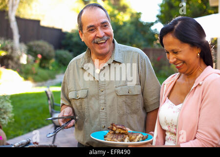 Il marito e la moglie a un barbecue in giardino Foto Stock