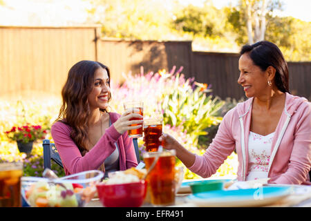 Madre e figlia tostare in giardino Foto Stock