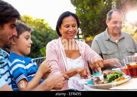 Tre generazioni la famiglia cenare in giardino Foto Stock