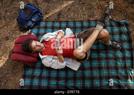 Vista aerea del giovane maschio camper giacente sulla coperta picnic in foresta, Los Angeles, California, Stati Uniti d'America Foto Stock