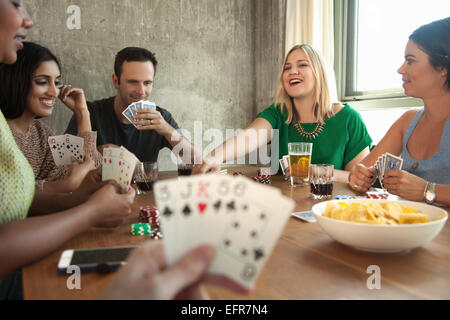 Gruppo di amici a giocare a carte intorno al tavolo Foto Stock