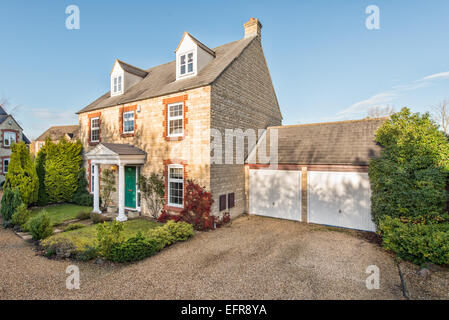 Un moderno tipico sviluppatore suburbana costruita casa & garage su uno sviluppo in Faringdon, Oxfordshire, Regno Unito su un soleggiato sumer sera Foto Stock