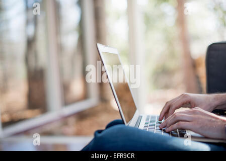 Close up di un uomo con le mani in mano, la digitazione sul suo computer portatile. Foto Stock