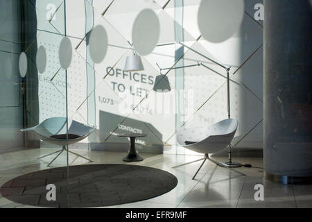 Le ombre di un segno per gli uffici di lasciare che sia visibile su una parete bianca in un foyer aziendale nella città di Londra. Foto Stock