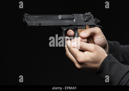 Mani maschio con la pistola isolati su sfondo nero Foto Stock