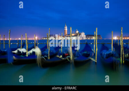 Riva degli Schiavoni e la Piazza San Marco island e la chiesa di San Giorgio Maggiore. Gondole attraccate al crepuscolo. Foto Stock